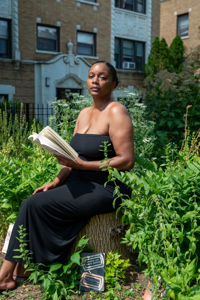 Rebelle Cunt captured reading a book while sitting in a garden shining under the sun. Photo by Tonal Mondae.