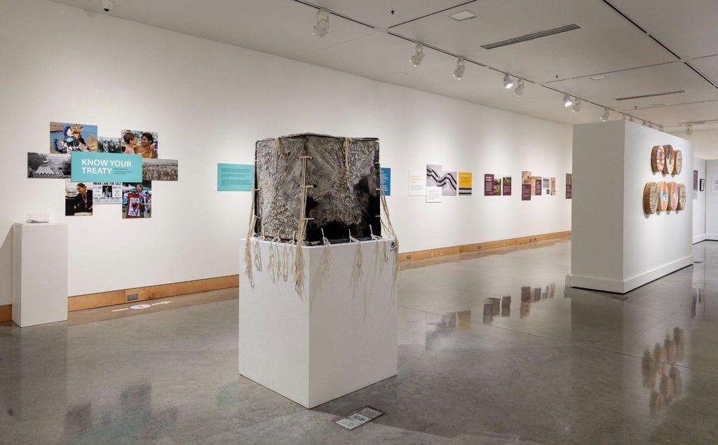 Installation view of Wiwahokichiyapi: They Promised Things to Each Other. Pictured in the center: Mikayla Patton, For Mom, 2023, Repurposed handmade paper, India ink, deer leather, smoked in Dakota sage. Image courtesy of Plains Art Museum.